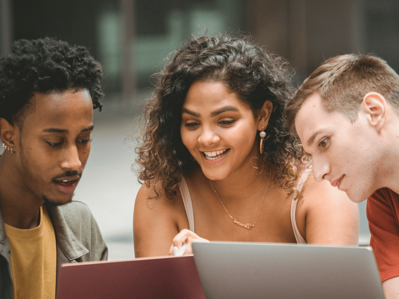 Drei Schüler*innen arbeiten zusammen an einem Projekt