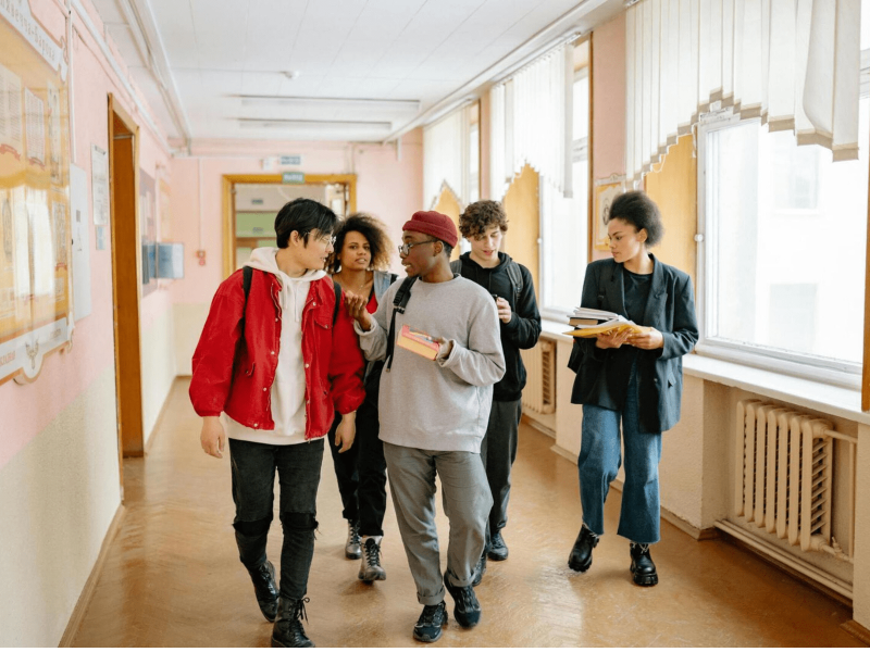 Selbstlernkurs Sichere Lernorte; eine Gruppe an Schüler*innen geht einen Gang entlang